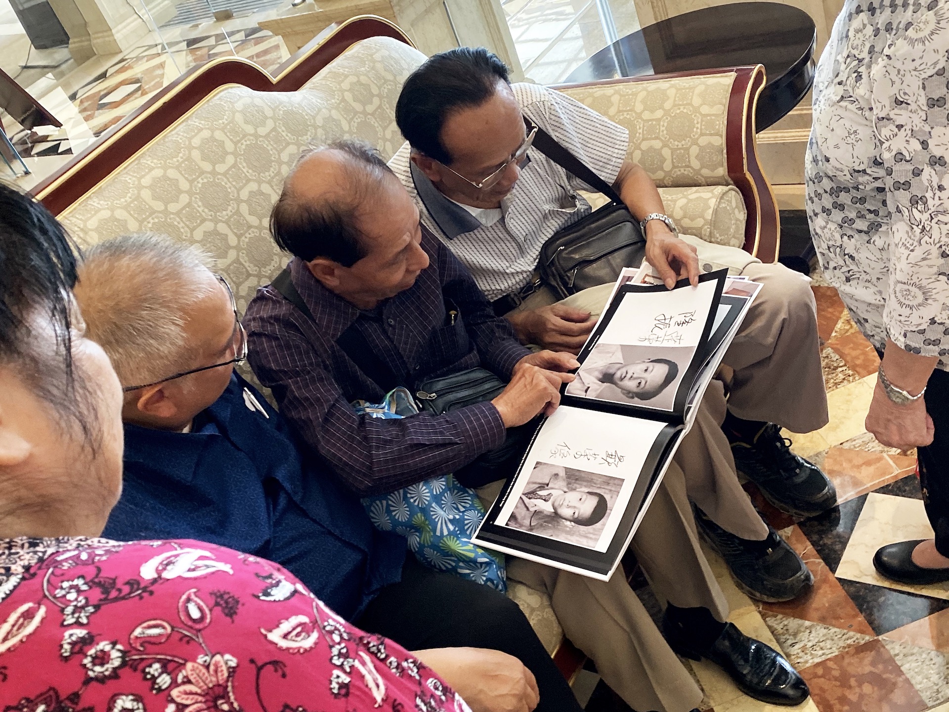 Reunited relatives reading their family history photo-book together