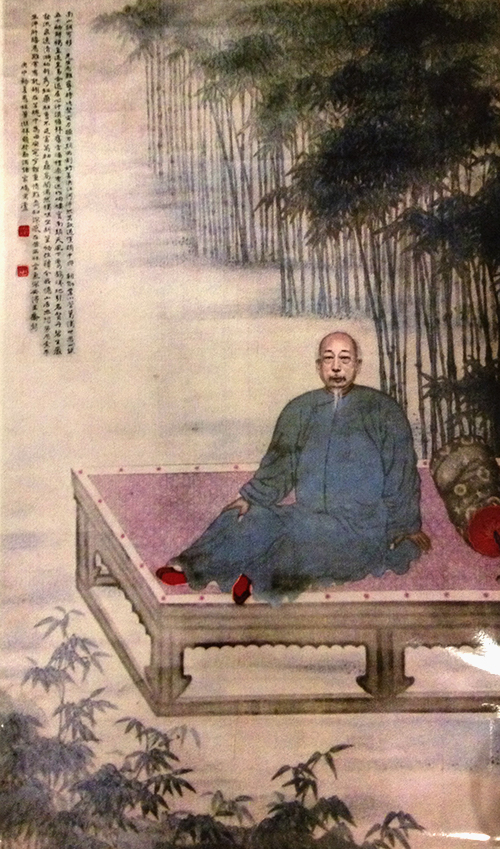 Scroll painting of elderly Chinese man lounging by a bamboo forest