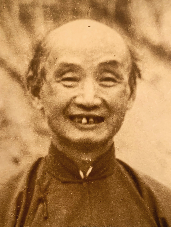 Vintage photo of balding Chinese man with a toothy grin