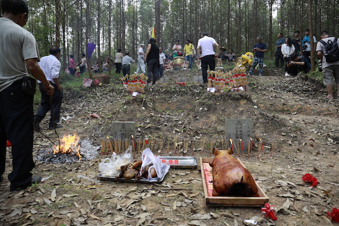 Clan members make offerings of meat and incense at their ancestral graves