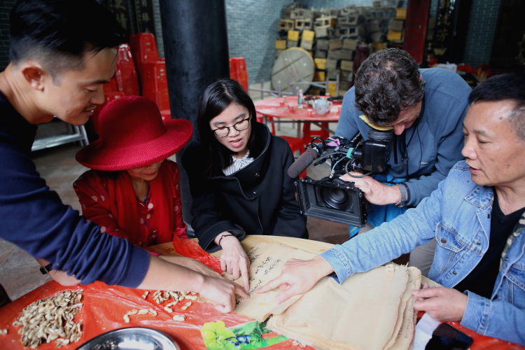 Ying helping read through the zupu ancestral book with Fai and translating to Ben