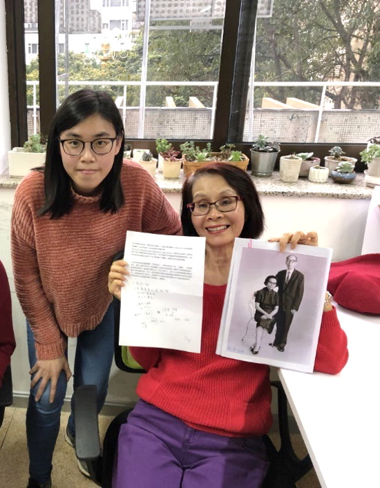 Ying next to our client’s mother Jenny Phang, holding up photos of her grandparents for her roots search