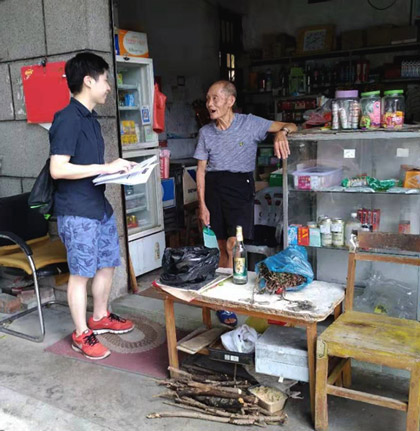 MCR researcher Waikwan speaks with a villager at a storefront