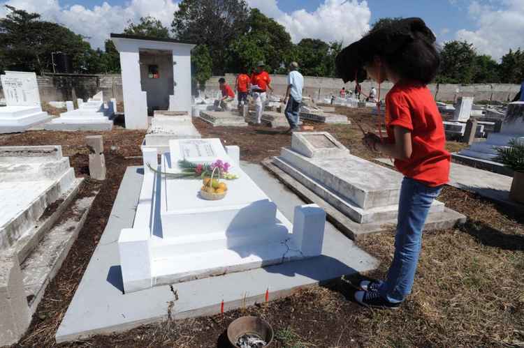 Jamaican girl honors the grave of an ancestor in the Kingston Chinese Cemetery