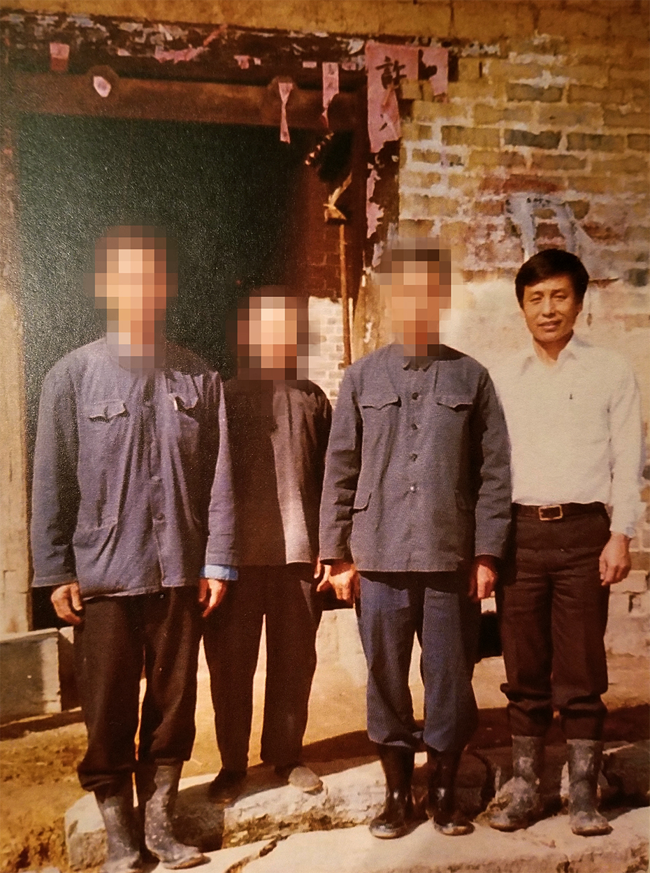 Four reunited relatives stand together in their ancestral village in China