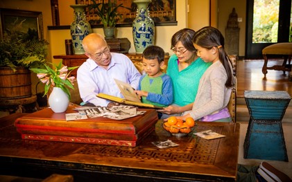 A Chinese family browsing family photos and memorabilia together.