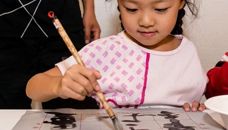 A Chinese girl enjoying an attempt at Chinese calligraphy.